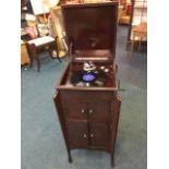 A stained mahogany cased wind-up gramophone, the player with hinged caddy shaped lid having
