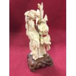 A 20th century carved ivory group of cockerel, hen & chicks on naturalistic ground with foliage,