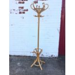 A beech bentwood coatstand, with six scrolled hooks on column, the base with waisted legs having