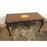 A rectangular mahogany coffee table, the scalloped top inlaid with oval floral marquetry medallion