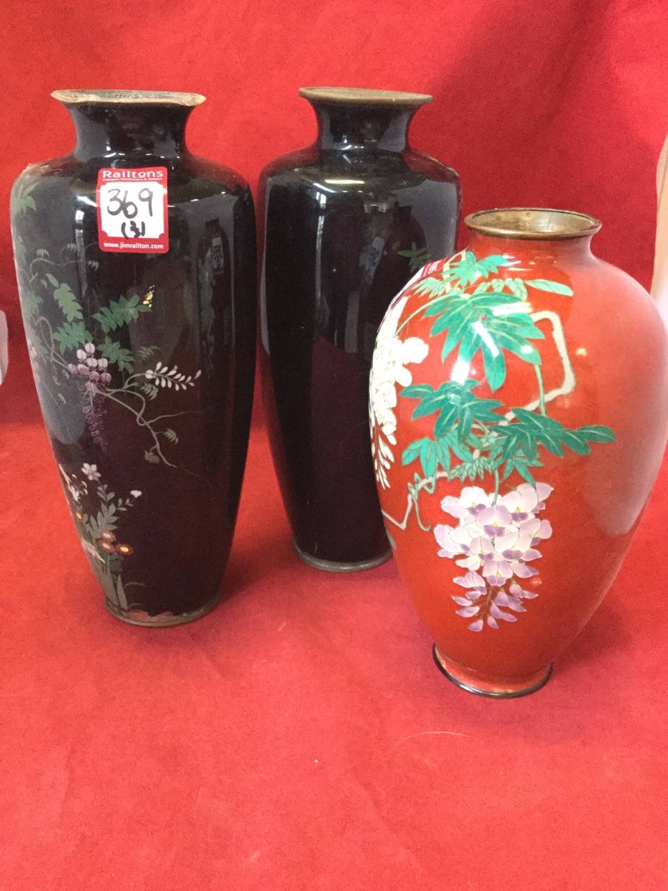 A pair of tapering late Victorian cloisonné vases decorated with birds and trailing foliage on black