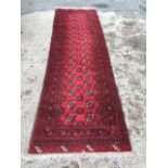 A Tekke style oriental runner woven with rectangular field having two rows of sixteen octagonal