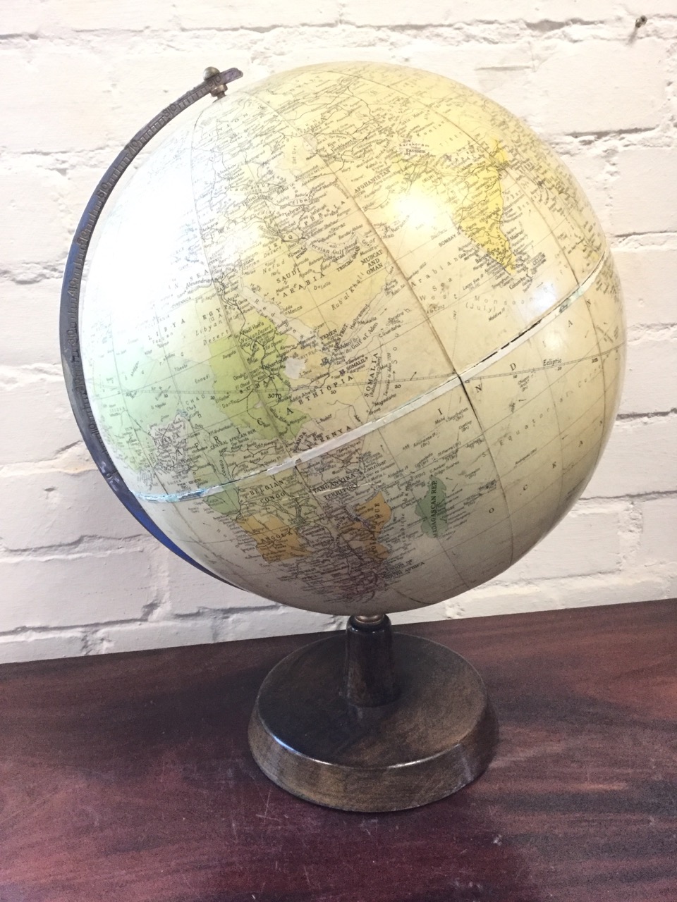 A 1959 Phillips Challenge globe on stand, having chromed axis arch revolving on tapering hardwood