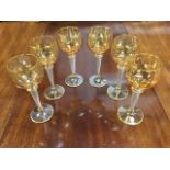 A set of six German Josephinehütte lustre hock glasses, the golden bowls with gilt rims supported on