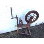 A Victorian hardwood spinning wheel, the angled oak platform on three turned legs with working