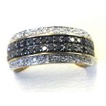 An unusual 9ct gold ring set with twin row of black diamonds, bordered by brilliant cut stones -