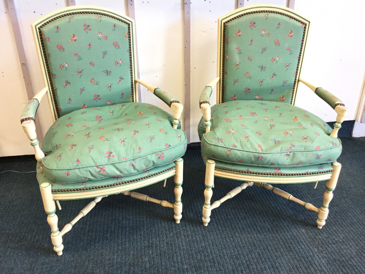A pair of painted upholstered armchairs, the arched moulded backs with brass studding framing