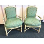 A pair of painted upholstered armchairs, the arched moulded backs with brass studding framing