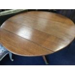 A Victorian oval oak dining table, the top with two drop-flaps supported on a bulbous turned column,