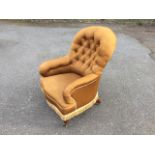 A Victorian button upholstered spoonback armchair, the sprung seat raised on turned legs with