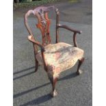 A nineteenth century mahogany armchair with moulded scalloped back framing a pierced carved splat,