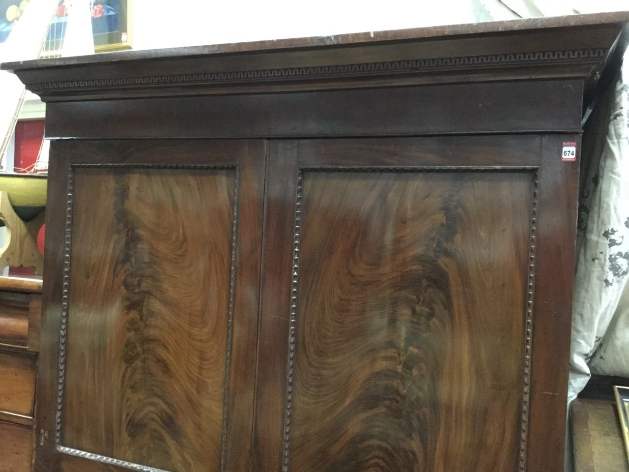 A nineteenth century mahogany wardrobe with moulded dentil cornice above flame panelled doors framed - Image 2 of 3