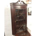 A Victorian mahogany hanging corner cupboard, with swan-neck cornice above a geometric inlaid
