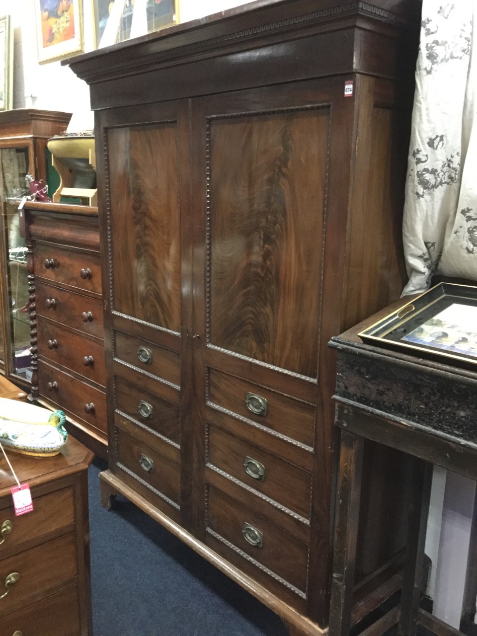 A nineteenth century mahogany wardrobe with moulded dentil cornice above flame panelled doors framed