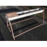 A 5ft galvanised rectangular feeding trough with ballcock water feeder, raised on square section