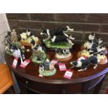 A collection of resin moulded sheepdog figurines including puppies, groups, with lambs, singles,
