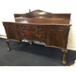 A late Victorian mahogany serpentine fronted sideboard, with shaped upstand and floral ribbon carved