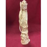 A signed carved ivory figure of a lady wearing engraved kimono holding lotus flower and standing