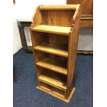 A Mexican pine open bookcase with four shelves beneath moulding, having panelled drawer to base. (