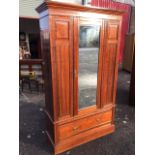 A late Victorian walnut wardrobe with moulded ogee cornice above a central bevelled mirror door