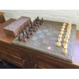A large chess set with leaf carved hardwood board having turned pieces in box - one pawn absent. (
