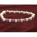 An 18ct white gold amethyst & diamond bracelet, with eighteen claw set amethysts weighing over