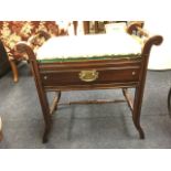 A late Victorian mahogany piano stool, the stud upholstered seat flanked by turned handles on scroll