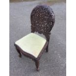 A Victorian Anglo-Indian carved hardwood chair, the rounded arched back intricately pierced with