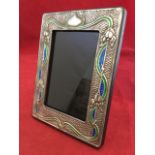 An art nouveau style sterling silver and enamel photo frame, embossed with naturalistic floral