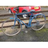 A painted gents bicycle, with long padded seat, mudguards, panier rack, Shimano gears, etc.