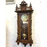 A large walnut cased Vienna wallclock, the crest with eagle mount above a gallery of spindles