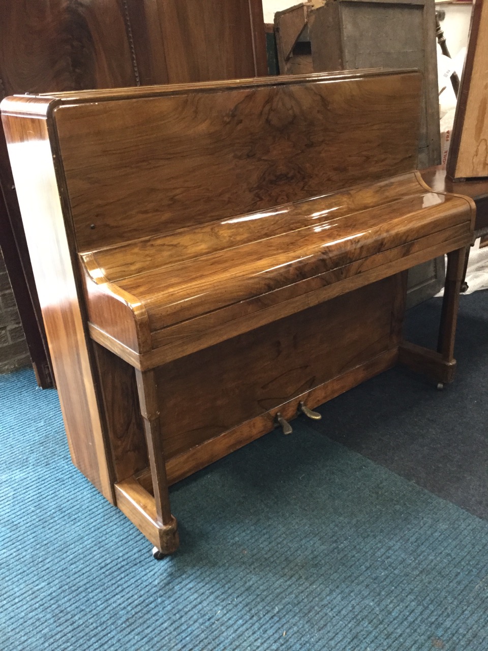 A 1930s walnut upright piano by Rogers Eungblut, with rounded case and seven octave keyboard