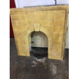 A 50s tiled fire surround, with arched aperture topped by wedge shaped keystone tile, the 4in