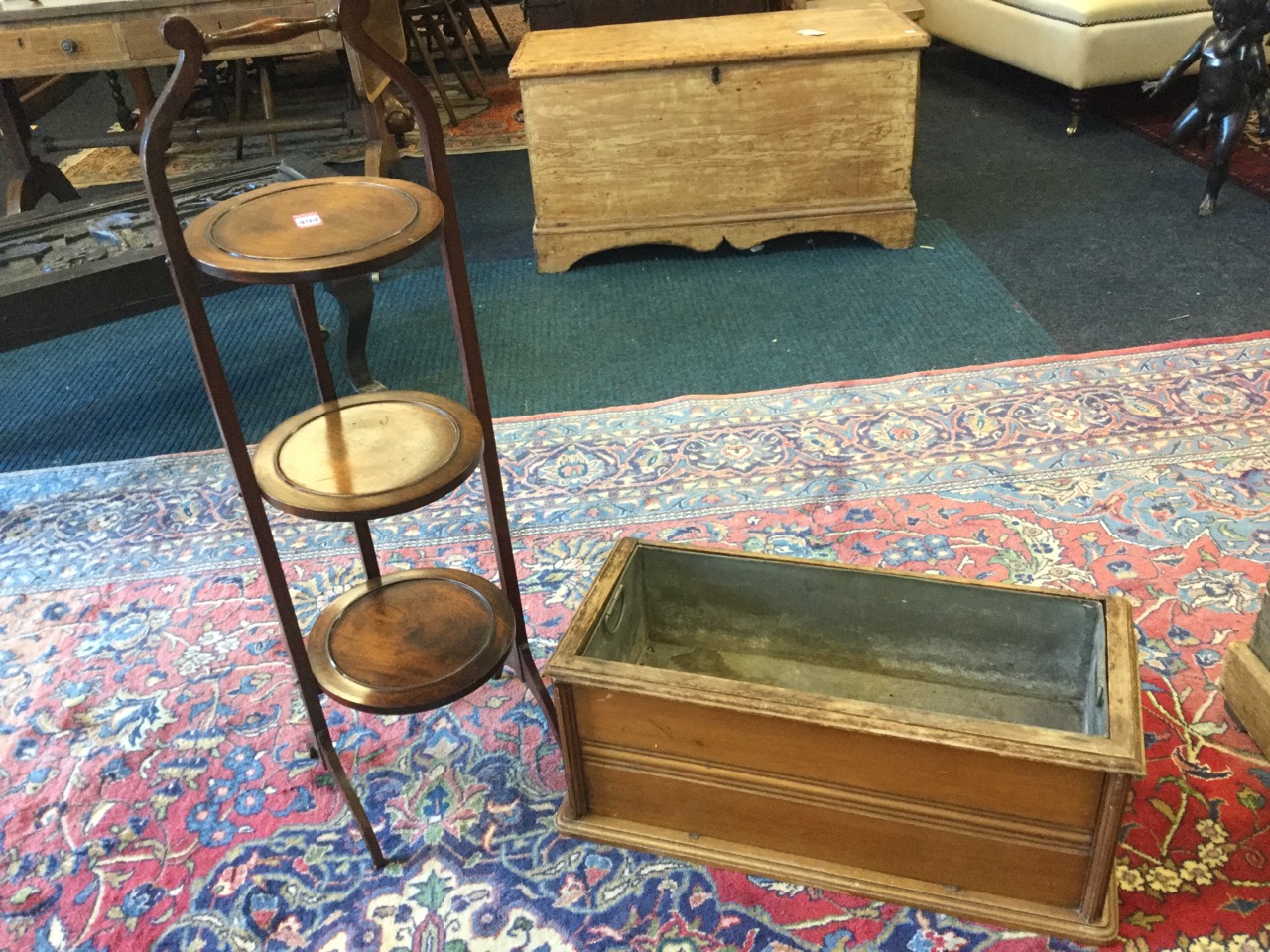 A three-tier Edwardian mahogany cakestand with circular folding platforms surmounted by turned