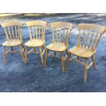 A set of four beech spindleback kitchen chairs, the shaped solid seats raised on turned legs &