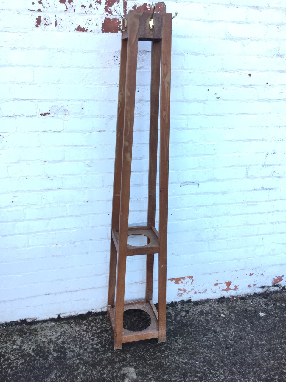 A square mahogany hatstand mounted with pegs, having angled rectangular legs joined by two platforms