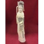 A carved walrus ivory figure of an elegant lady, wearing traditional robes and sword, holding sick