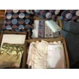 A pair of square grid cushions; three boxes of textiles - towels, bedding, some new fabric, some