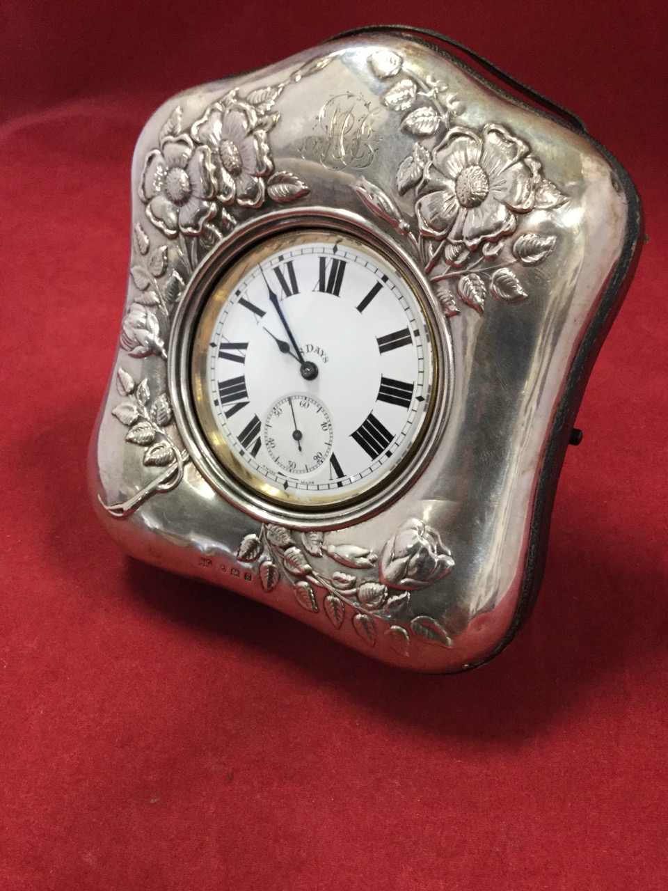 A silver cased pocketwatch, the floral embossed shaped leather backed frame hallmarked Birmingham