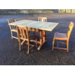 An oak draw-leaf dining table, the panelled top on twin moulded pillars with shaped sledge feet