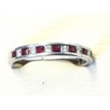 An 18ct white gold ruby & diamond eternity ring, the princess cut rubies weighing almost half-a-