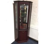 A reproduction mahogany corner cabinet, having illuminated mirrored interior, the glazed door with