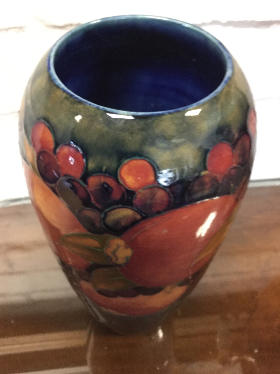 A tall tapering Moorcroft vase embossed with tube-lined vines and pomegranates on dark glazed ground - Image 2 of 3