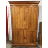 A late Victorian pine press cupboard with moulded ogee cornice above four tongue & groove panelled