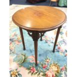 A circular Edwardian mahogany lamp table, the moulded top inlaid with central ribbon medallion and