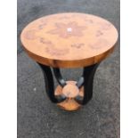 A circular deco style burr walnut occasional table, the segmented top on ebonised shaped legs