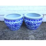 A pair of blue & white jardinieres with floral decoration framed by lotus leaf bands, the flat