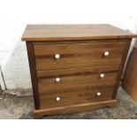 A contemporary pine chest of three long drawers mounted with porcelain knobs, above a shaped apron &