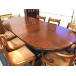 A reproduction twin pedestal mahogany dining table, the crossbanded top with ribbed edge supported