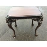 A reproduction mahogany centre table, the rectangular cut-corner top having carved horseheads to